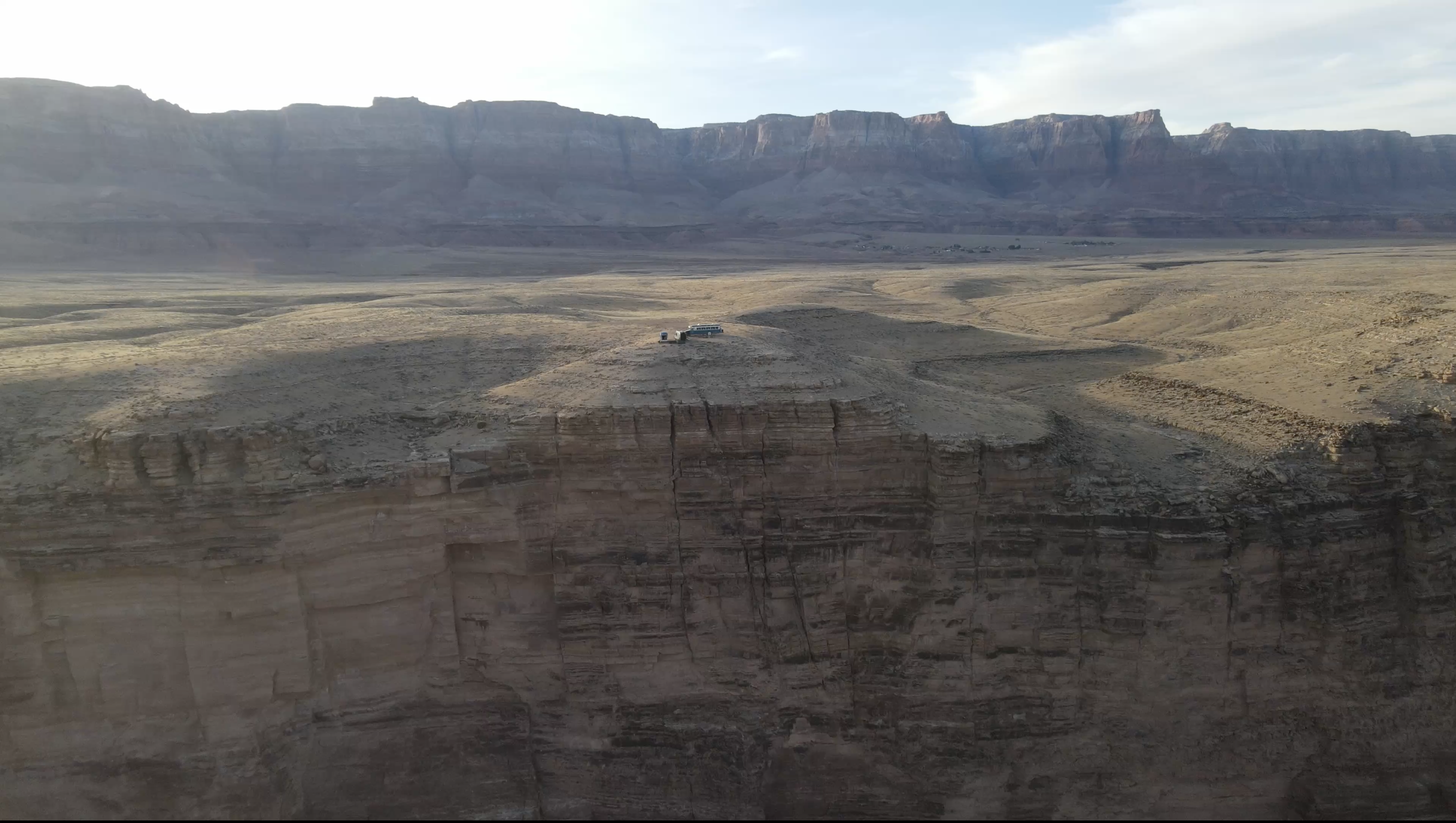 Two vans perched on the edge of a cliff above the Colorado River canyon, Arizona Strip