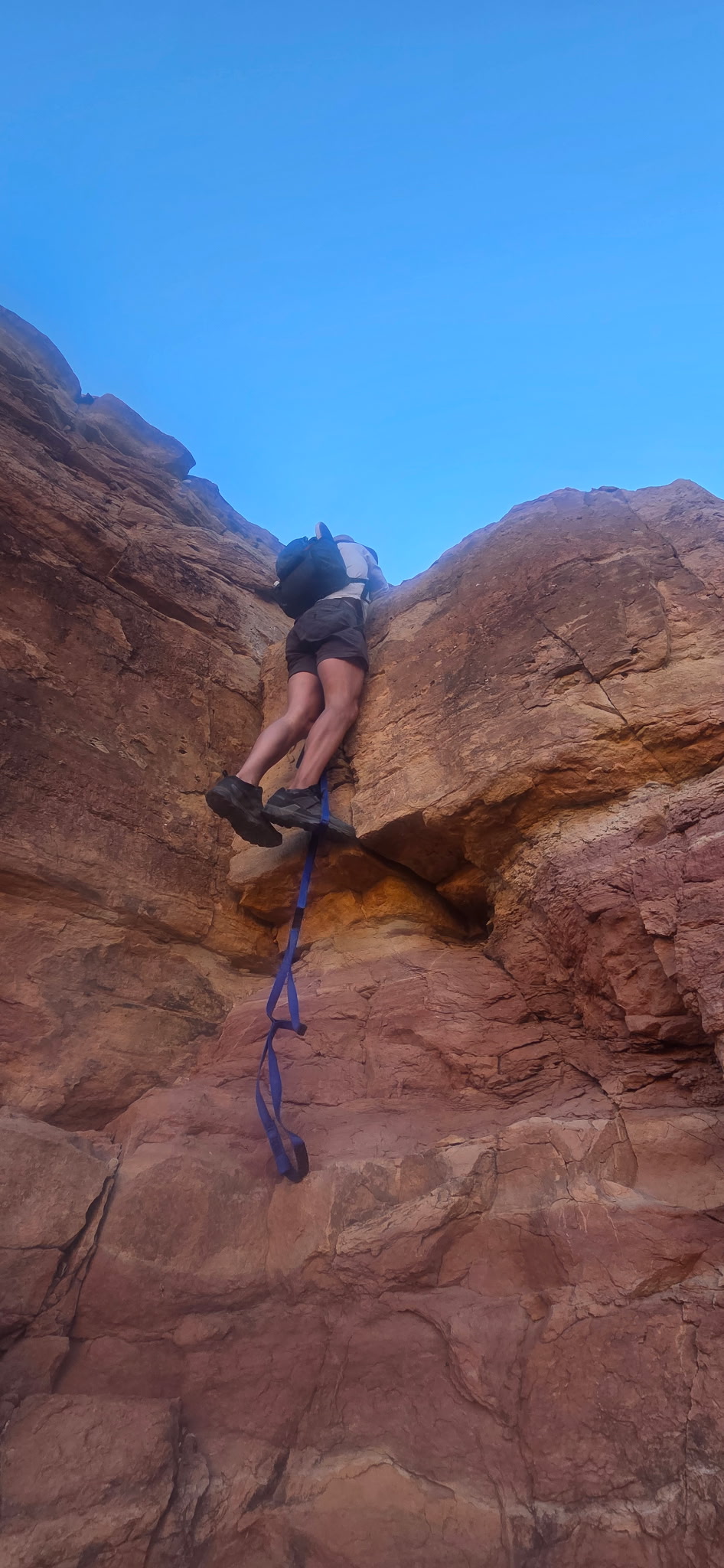 Climbing the blue rope up a sheer canyon wall